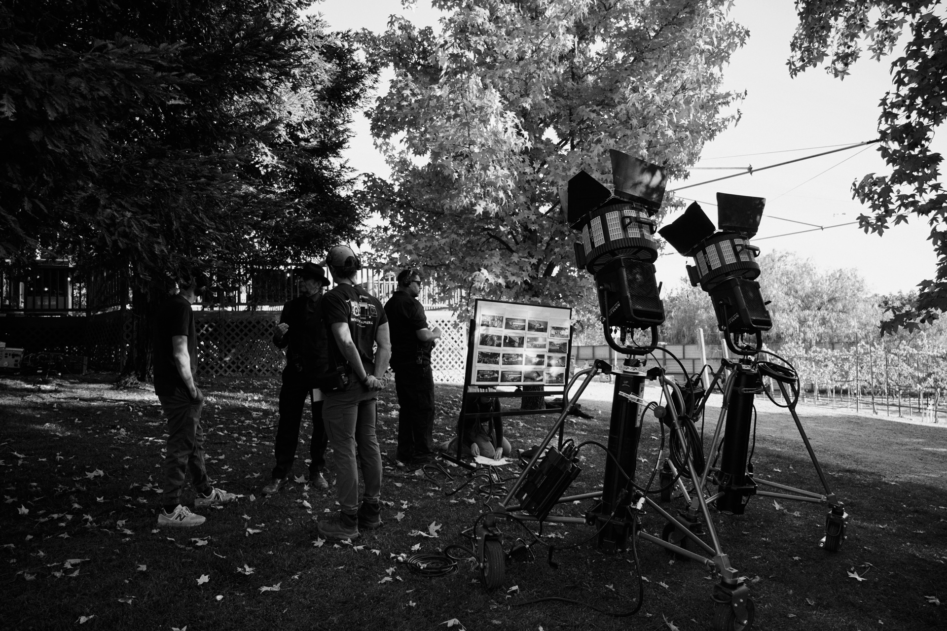 Taylor with crew reviewing storyboards beside two lights on set